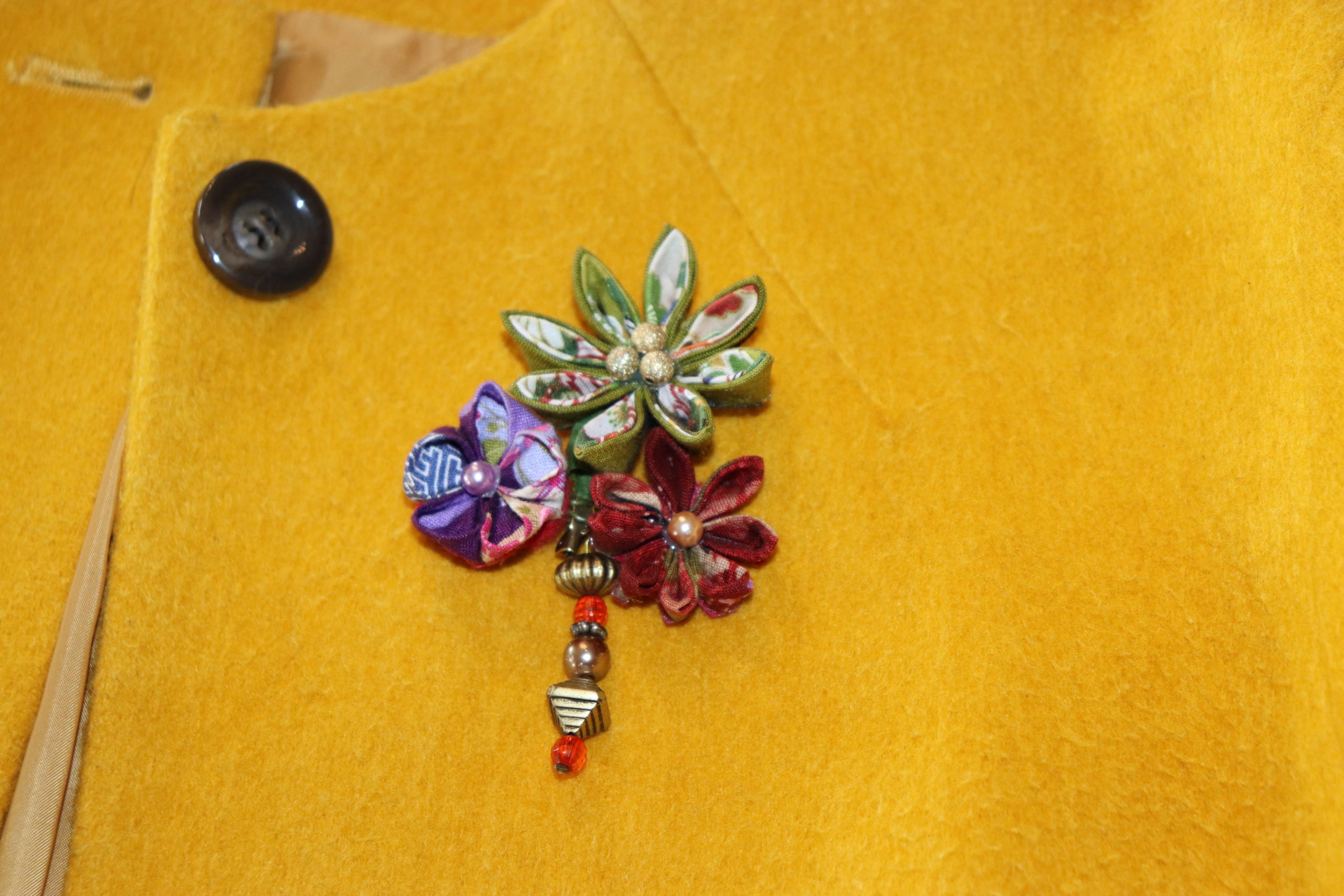 Broche trois fleurs verte, rouge et violette